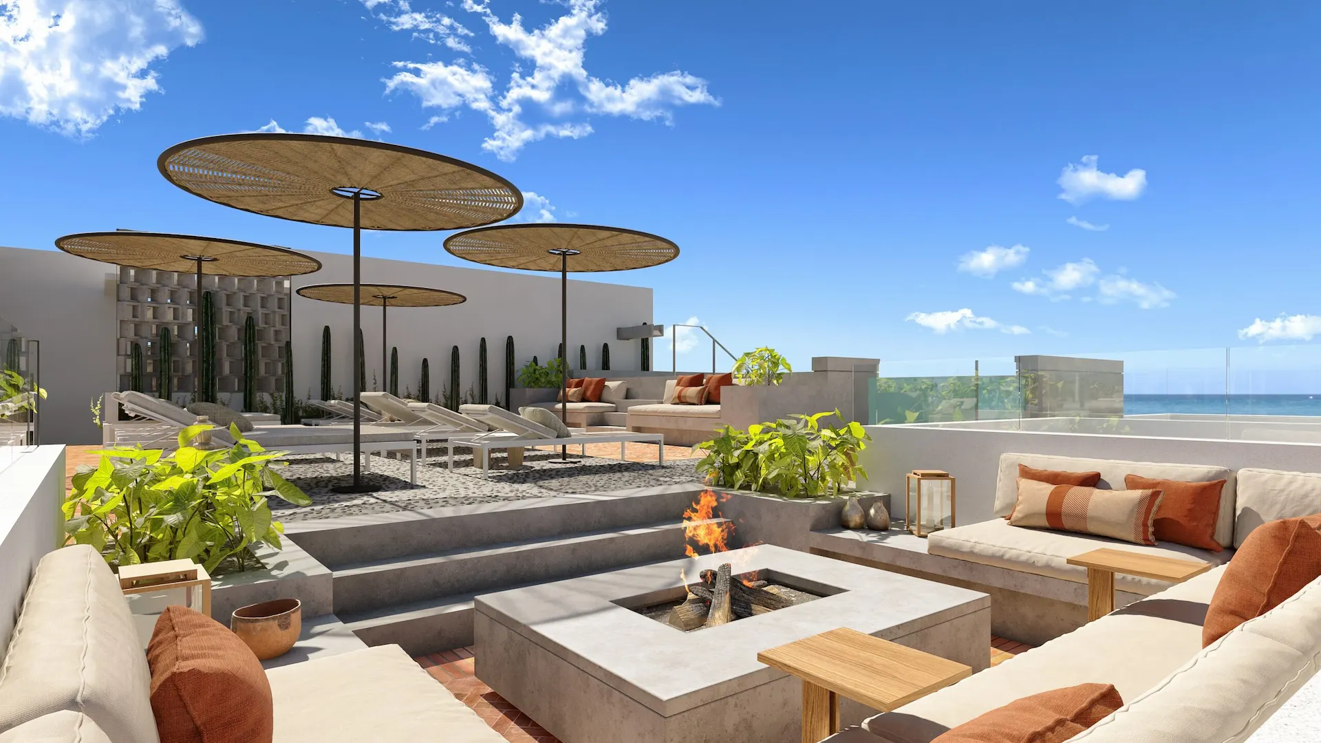 Rooftop terrace with sofas, sun chairs, umbrellas, and sea views
